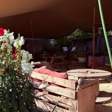 Une terrasse sous une toile tendue, dans un domaine viticole familial