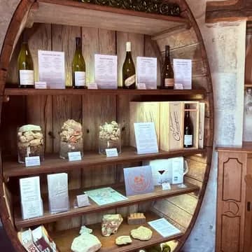 Une cave en bois en forme de tonneau, garnie de bouteilles de vin et de fiches