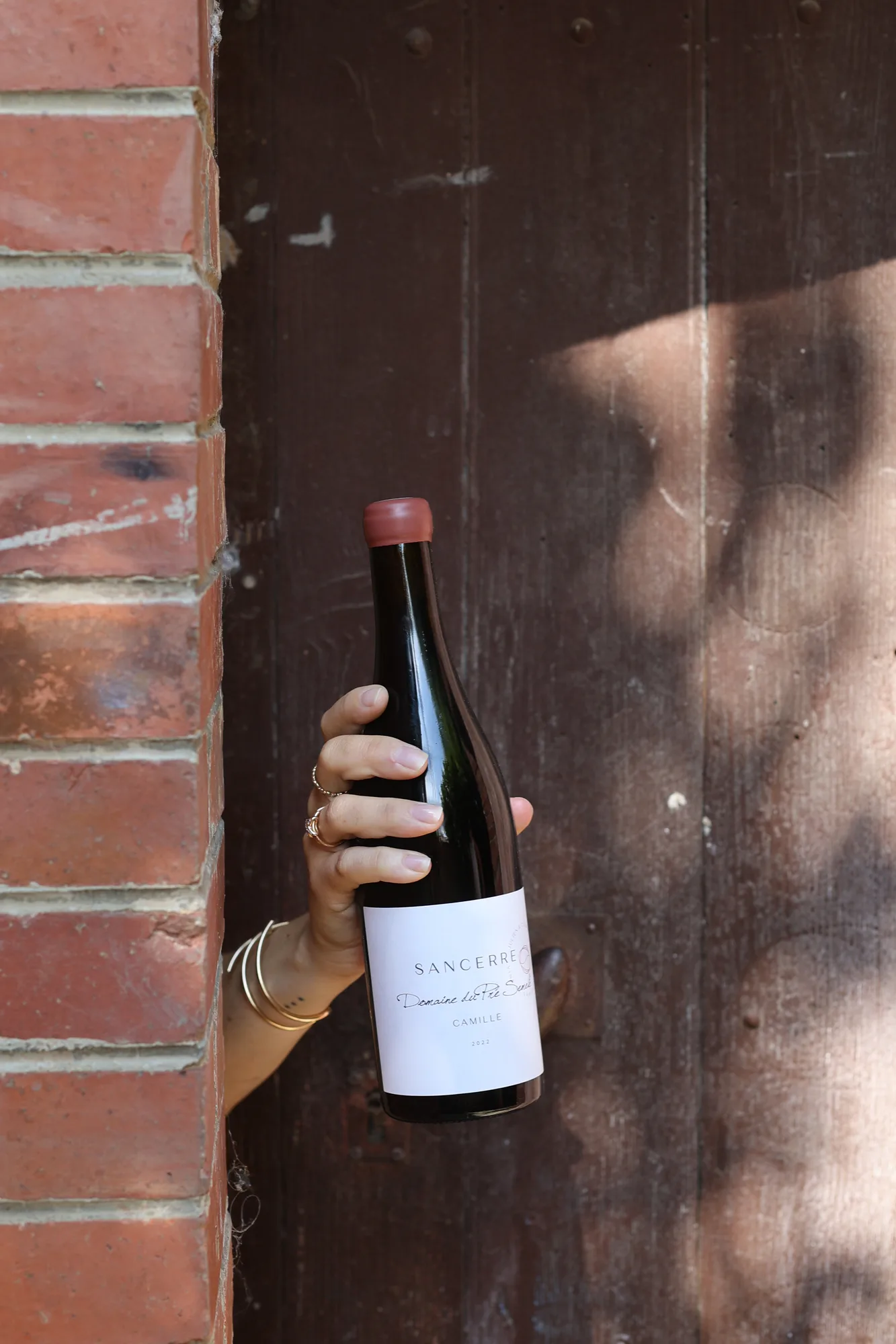 Une bouteille du Domaine du Pré Semelé contre un mur de pierre