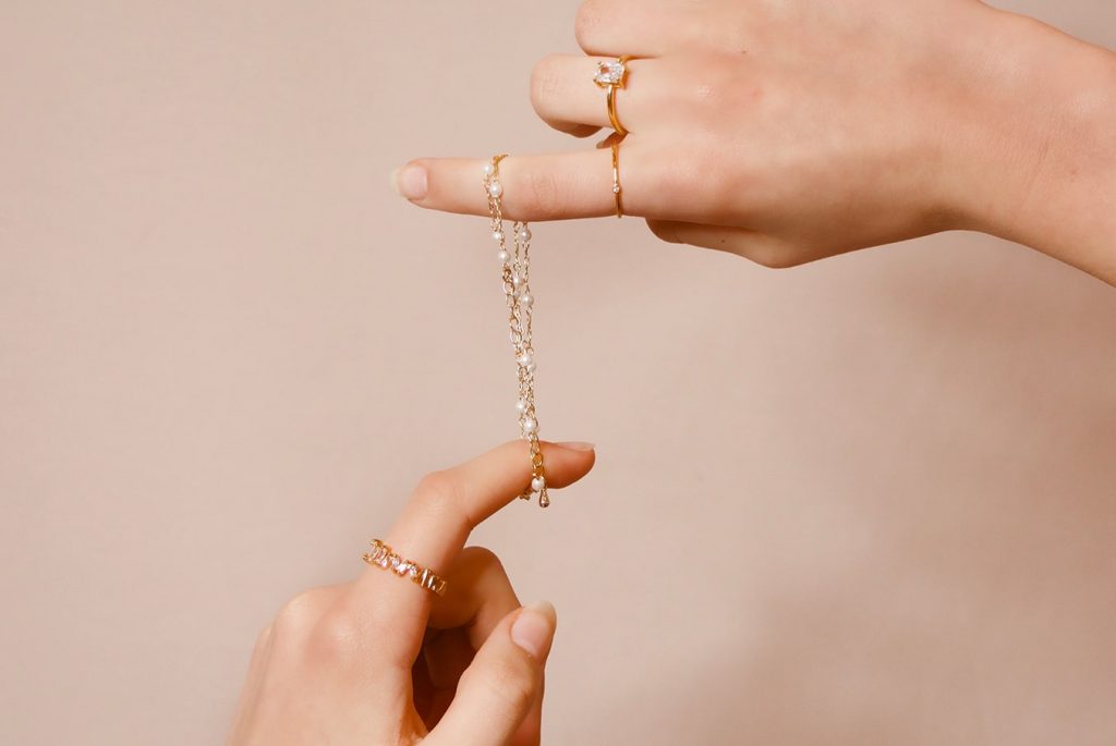 Image de mains qui tiennent des bijoux de créateur artisanal.